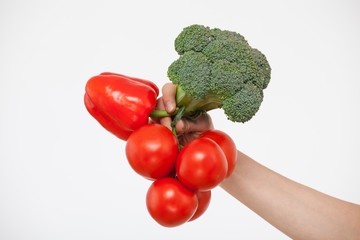 Female hand holding a bunch of tomatoes, broccoli and pepper