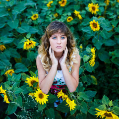 Attractive young girl in the field of sunflowers