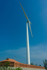 Fototapeta na wymiar White wind turbines generating electricity on blue sky
