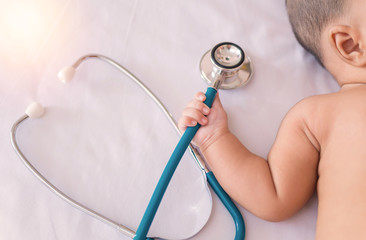 medical instruments stethoscope in hand of newborn baby girl - obrazy, fototapety, plakaty