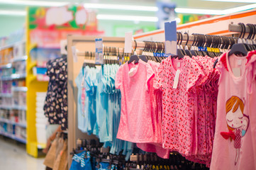 Girl pink tops with different patterns on hangers in store