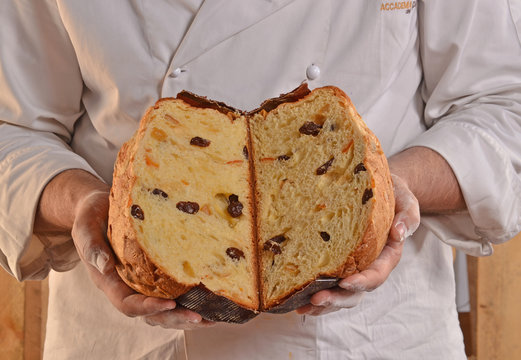 Panadero sujetando un panetone abierto por la mitad,recien horneado.