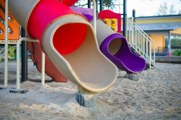 Red and violet pipe slides on modern kids playground