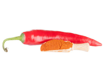 Pod of red hot chili pepper and ground paprika in a wooden spoon