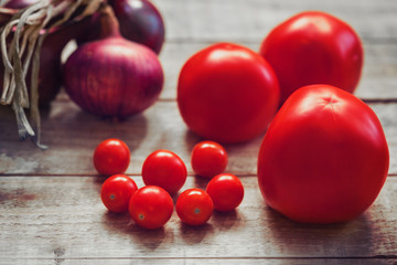 Tomatoes and onions on wooden background