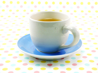 tea in cup on sweet polka dot background