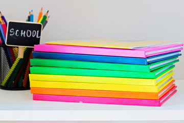 Fototapeta premium Multi colored books in stack on the light-coloured bookshelf