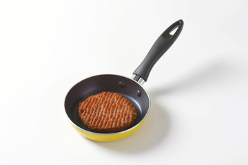 Beef burger patty in pan