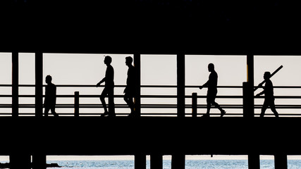 People walking across the bridge.