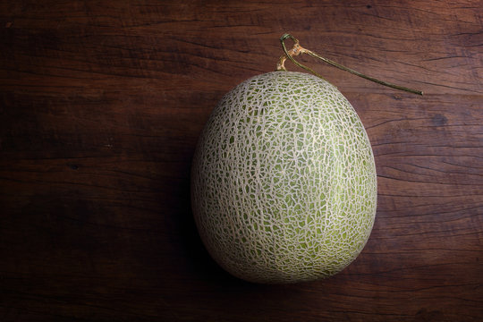 Fresh organic Japanese melon on wooden table
