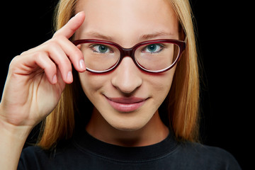Fototapeta premium Lächelnde Frau mit Hand an der Brille