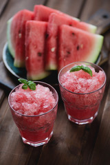 Watermelon granitas and sliced ripe watermelon in the background