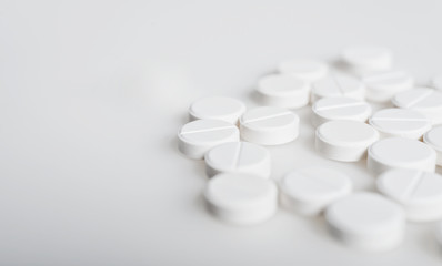 Spilled white pills on the white surface