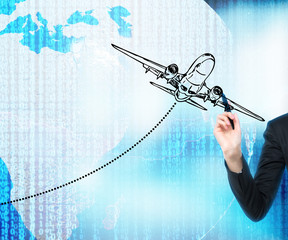 A hand is drawing an airplane over the digital world with binary code on the background. Elements of this image furnished by NASA.