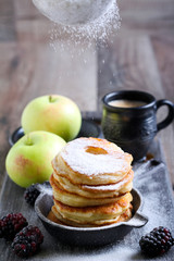 Dusting with icing sugar over apple fritters