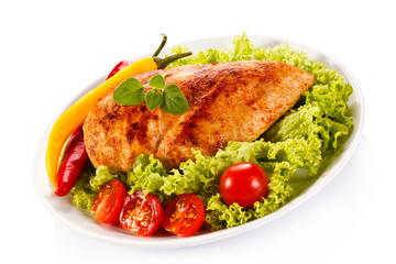 Roast chicken fillet and vegetables on white background 