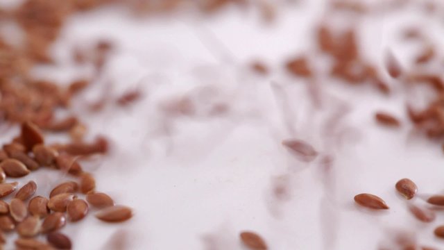 HD 1080 close up: flax seed falling down at plate forming small heap