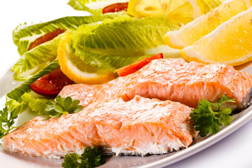 Roasted salmon and vegetables on white background