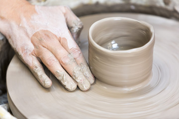 Making a pottery cup on the wheel