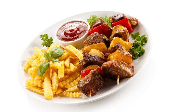 Grilled meat, French fries and vegetables 