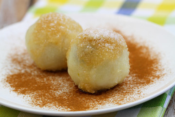 Sweet dumplings sprinkled with sugar and cinnamon, closeup

