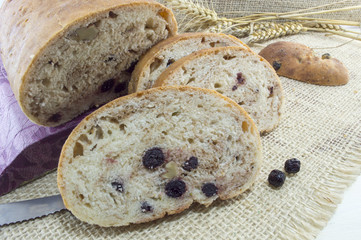 Fruit bread with aronia sliced on a wooden plate with dried aron