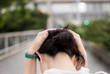 Naklejka premium 歩道で頭を抑える女性