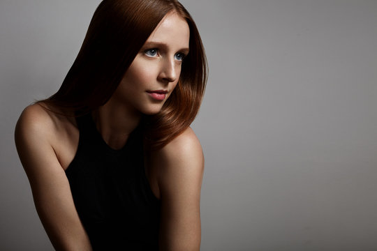 redhead girl with a blue eyes on a grey background