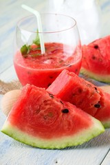 Couple of melon slices in front of fruit smoothie