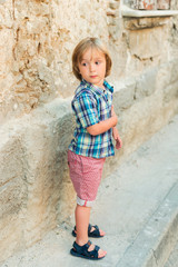 Fashion little boy wearing blue plaid shirt and red printed shorts