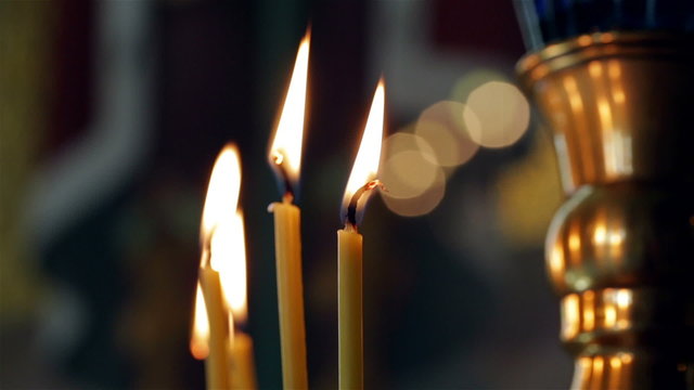 Close up of burning candle fire in church
