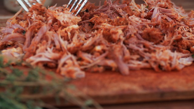 Pulled pork on a vintage wooden board looking deliciously tender