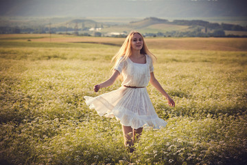 Fototapeta na wymiar Healthy beautiful woman walking outdoors. Alluring young woman in wheat field, delicate sensual woman on nature. perfect skin, curly hair.