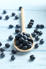 Blueberries in spoon on a blue wooden background