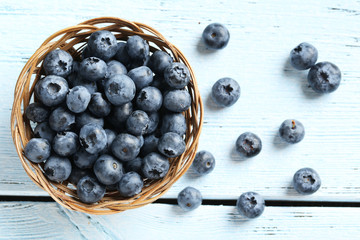 Blueberries in basket on a blue wooden background