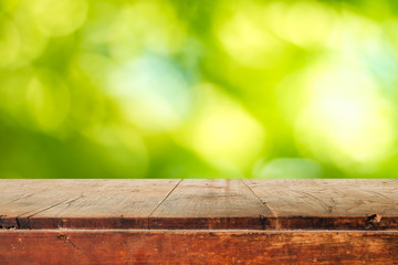 Empty wooden table and green natural spring blur bokeh backgroun