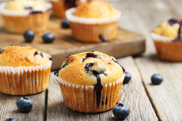 Tasty blueberry muffins on a grey wooden background