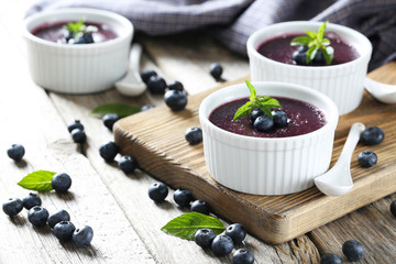 Delicious blueberry mousse in bowls on grey wooden table
