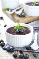 Delicious blueberry mousse in bowls on grey wooden table