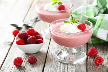 Sweet raspberry mousse in glass on grey wooden table