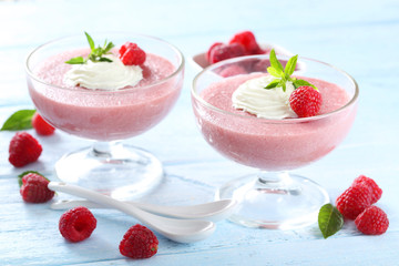 Sweet raspberry mousse in glass on blue wooden table