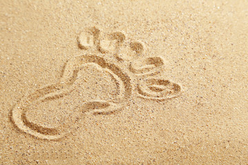 Drawing foot on beach sand