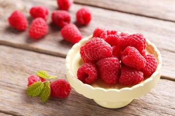 Red raspberries on cake stand on grey wooden background