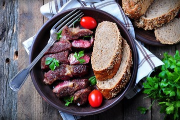 Delicious juicy rare beef steak with rye bread bran