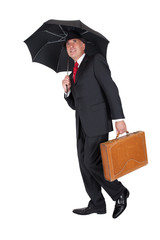 Businessman with umbrella holding a briefcase on white 