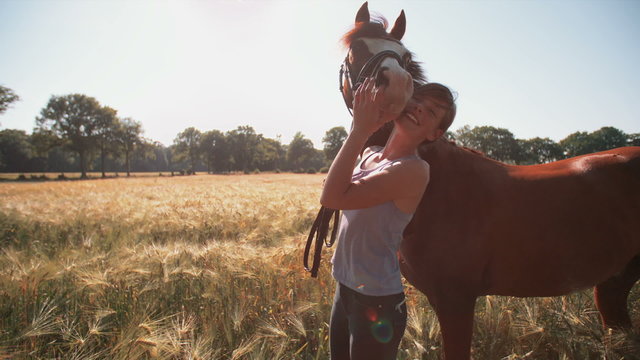 Girl giving her horse a friendly hug outdoors