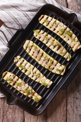 zucchini with cheese on a grill pan close-up. vertical top view
