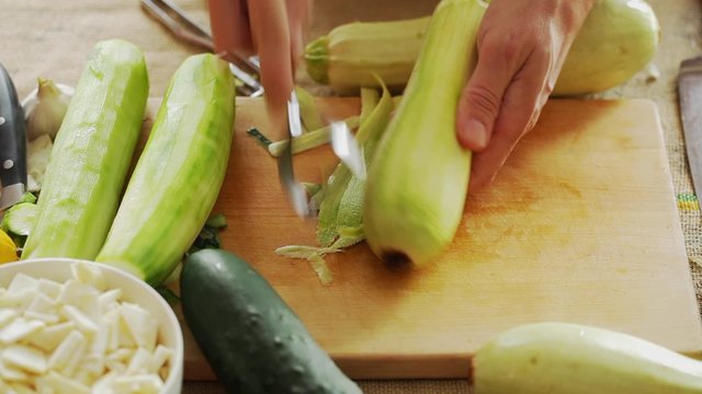 HD 1080 static: chef peeling zucchini using hand peeler tool; close up