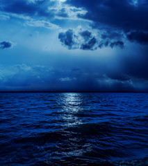 Fototapeta premium moonlight in clouds over water