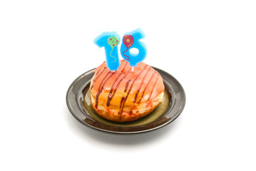 donut with sixteen years birthday candle on white